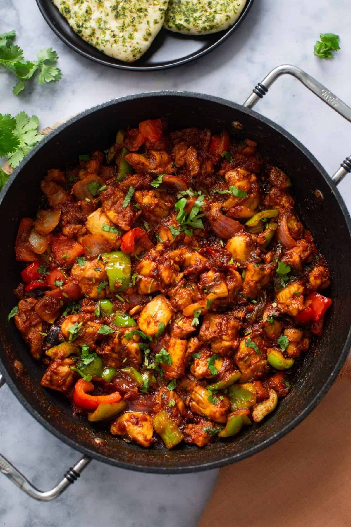 Chicken jalfrezi in a large black skillet.
