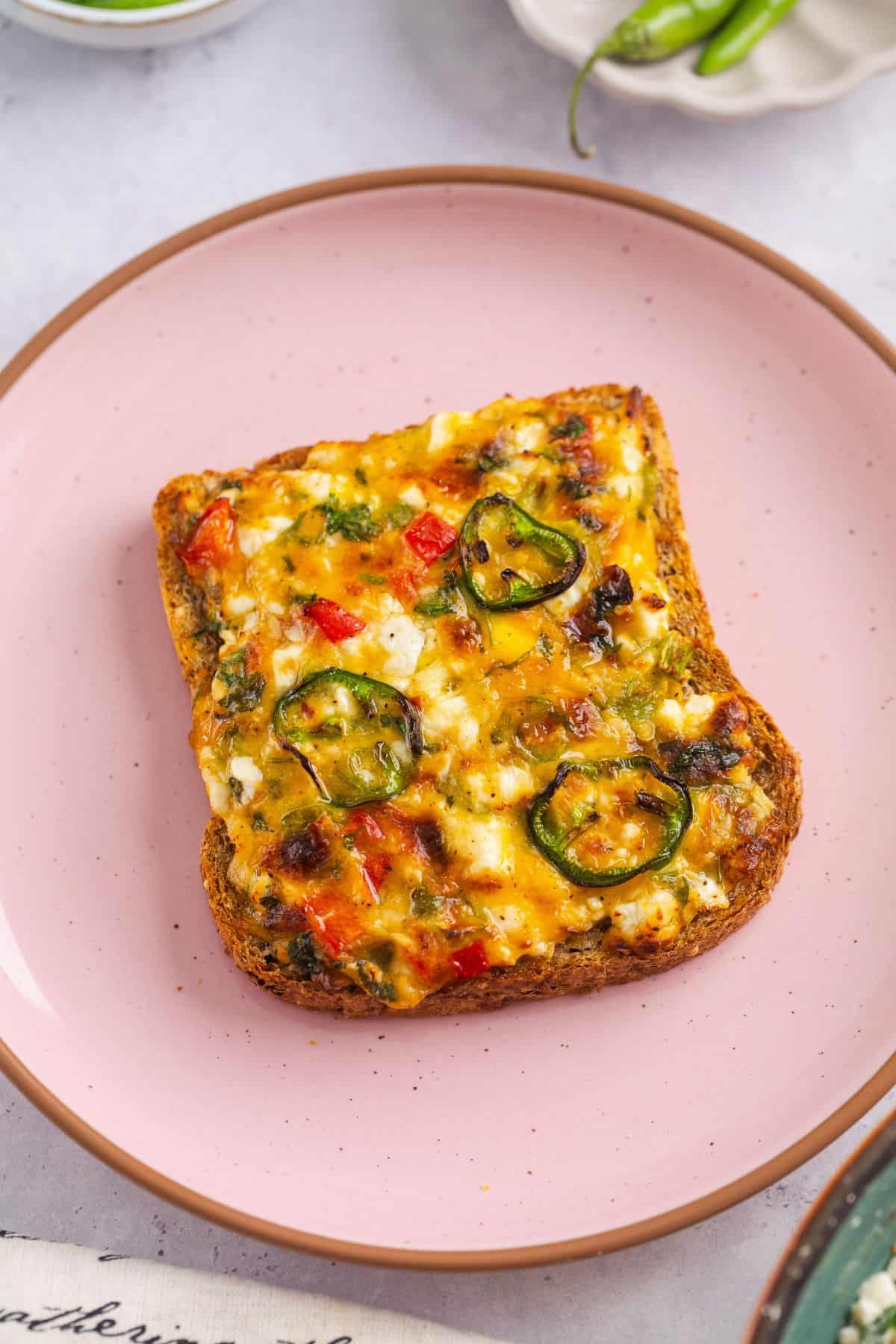 15-Minute Cottage Cheese Chilli Toast 17 Whole chili cheese toast placed on a ceramic pink plate.