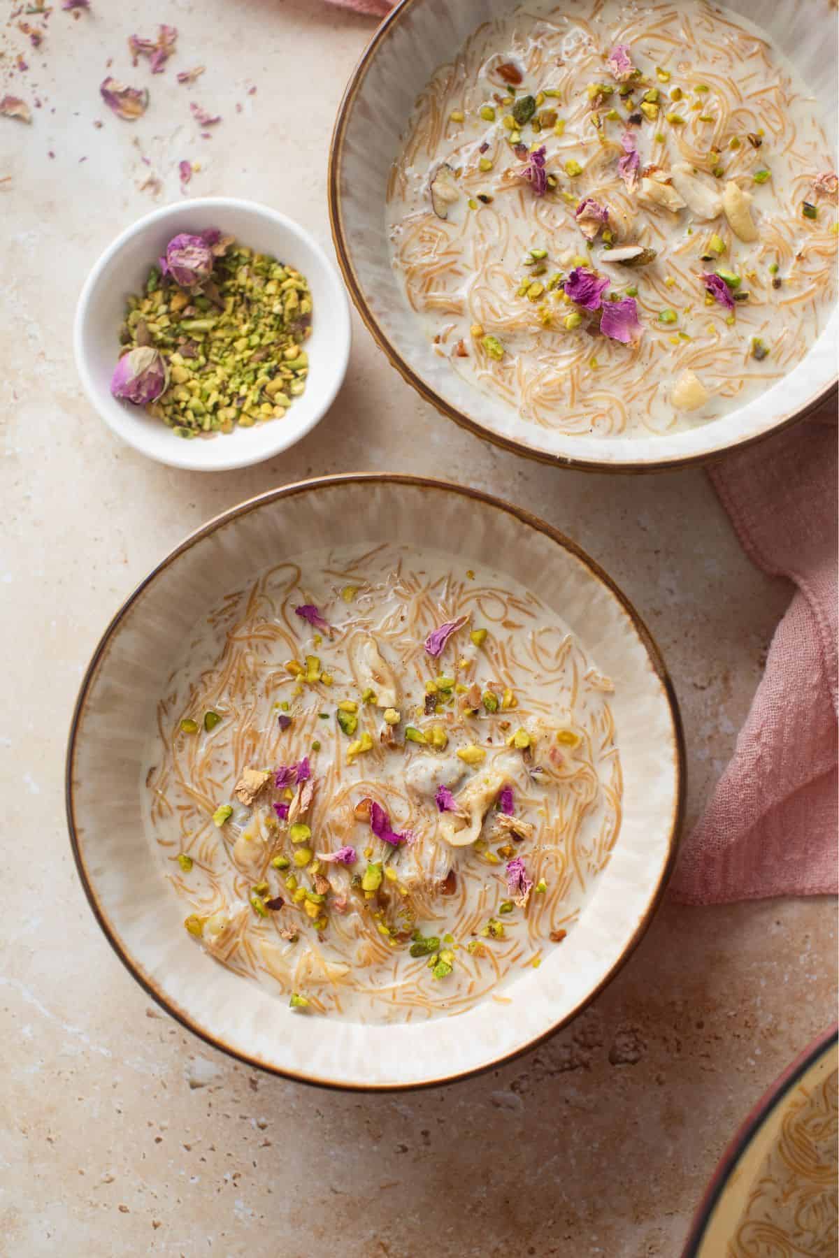 Indian Seviyan Recipe (Creamy Vermicelli Kheer ) 5 Two bowls of creamy vermicelli kheer garnished with nuts and dried rose petals.