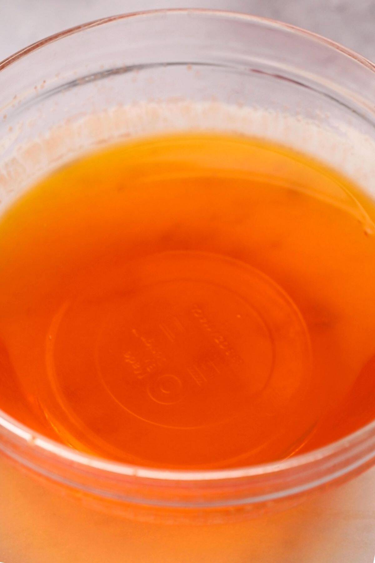 Orange jelly mixture in a glass bowl.