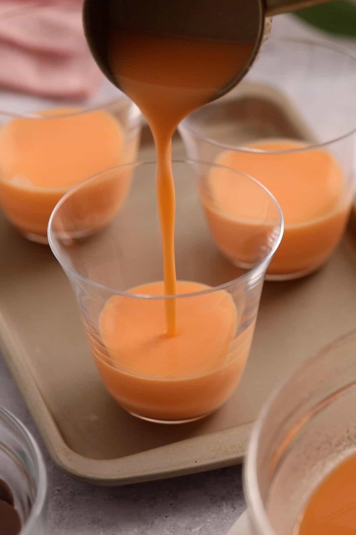 Jelly mixture is poured in glass dessert cups.