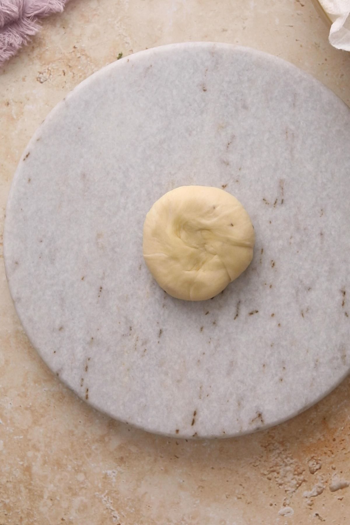 Classic Punjabi Samosa Recipe (Crispy & Flaky) 11 Dough ball is flallened and palced on a marble roling board.