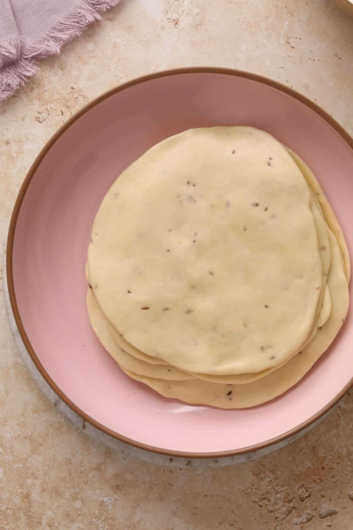 Classic Punjabi Samosa Recipe (Crispy & Flaky) 15 A pink bowl with all the rolled out samosa dough.