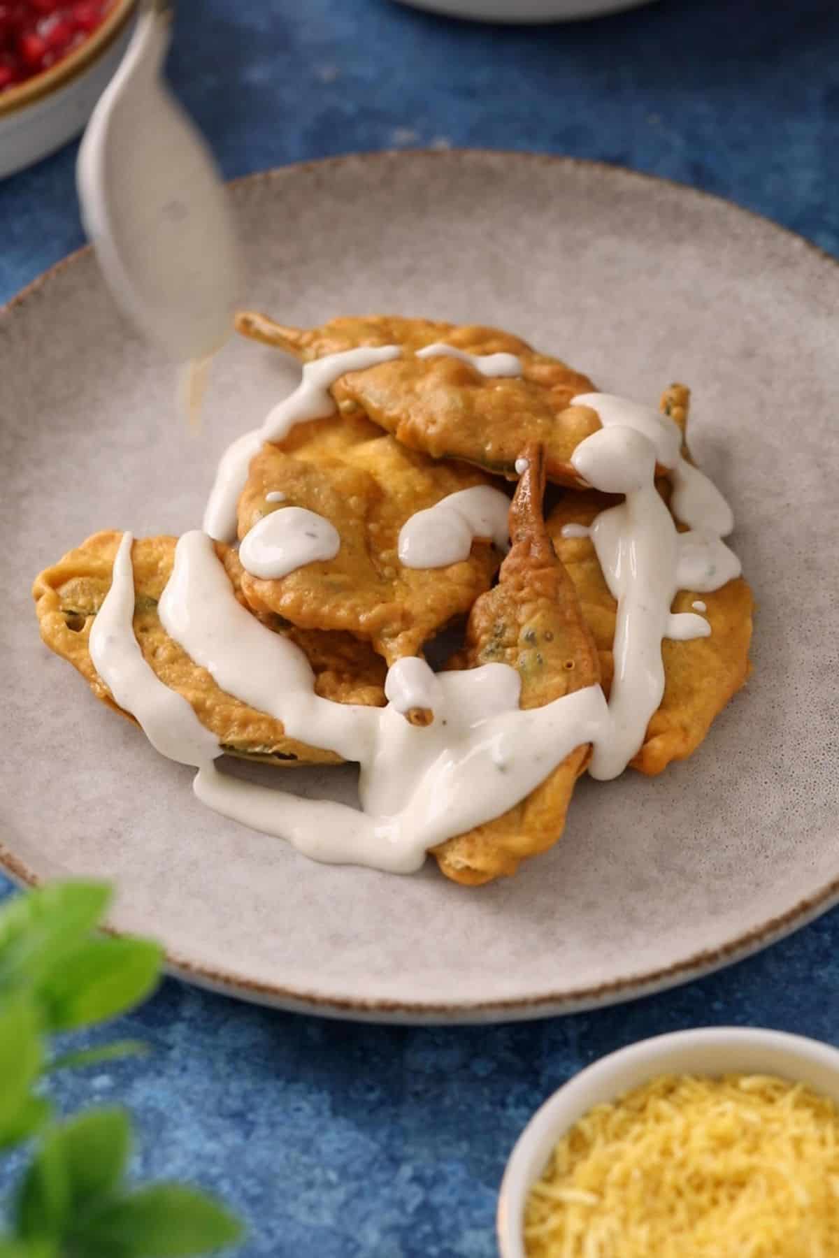 Delhi Style Palak Patta Chaat 29 Yogurt is drizzled over fried spinach leaves.