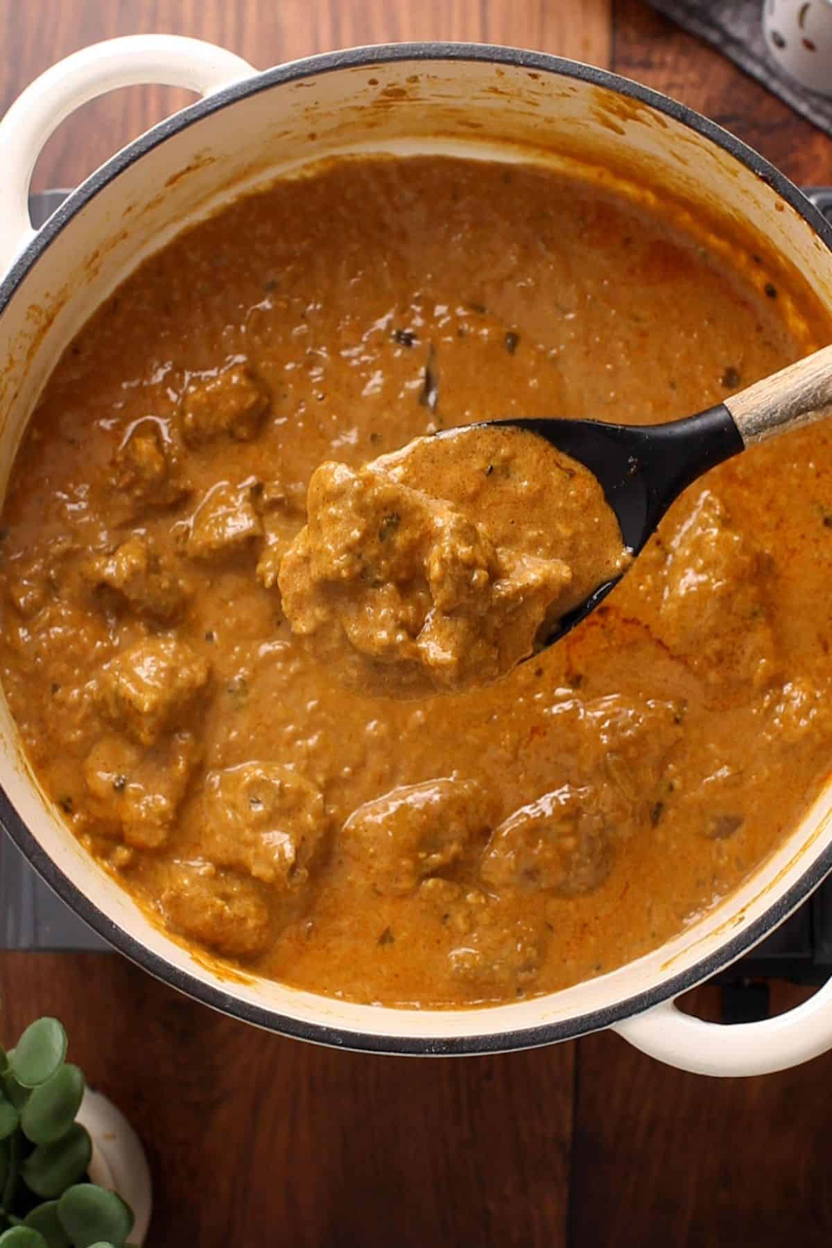 Restaurant-Style Lamb Korma (Rich & Creamy) 30 Lamb korma is in a black and wooden spoon.