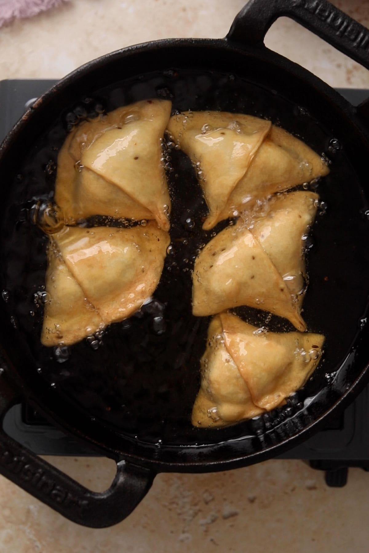 Samosa are fried til golden in hot oil.