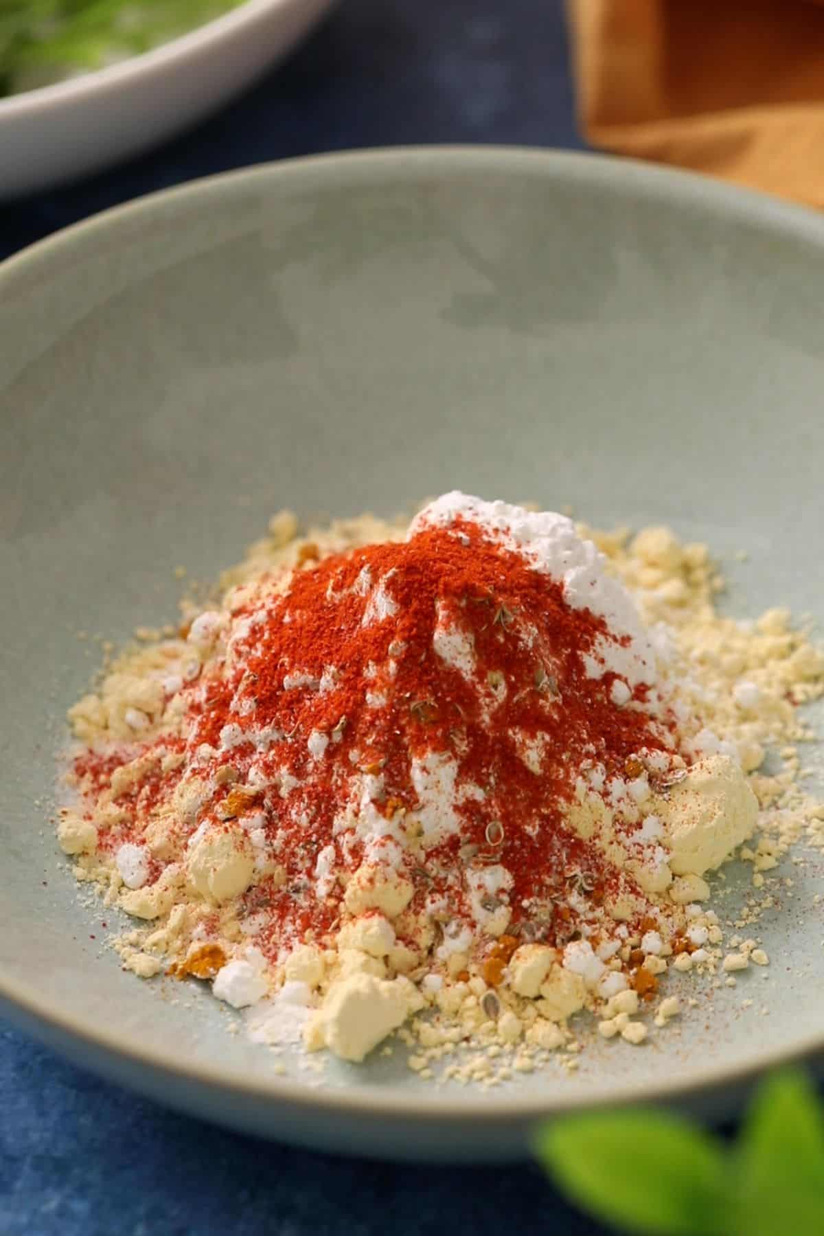 Delhi Style Palak Patta Chaat 13 Gram flour, rice flour and spices in a shallow sea green bowl.