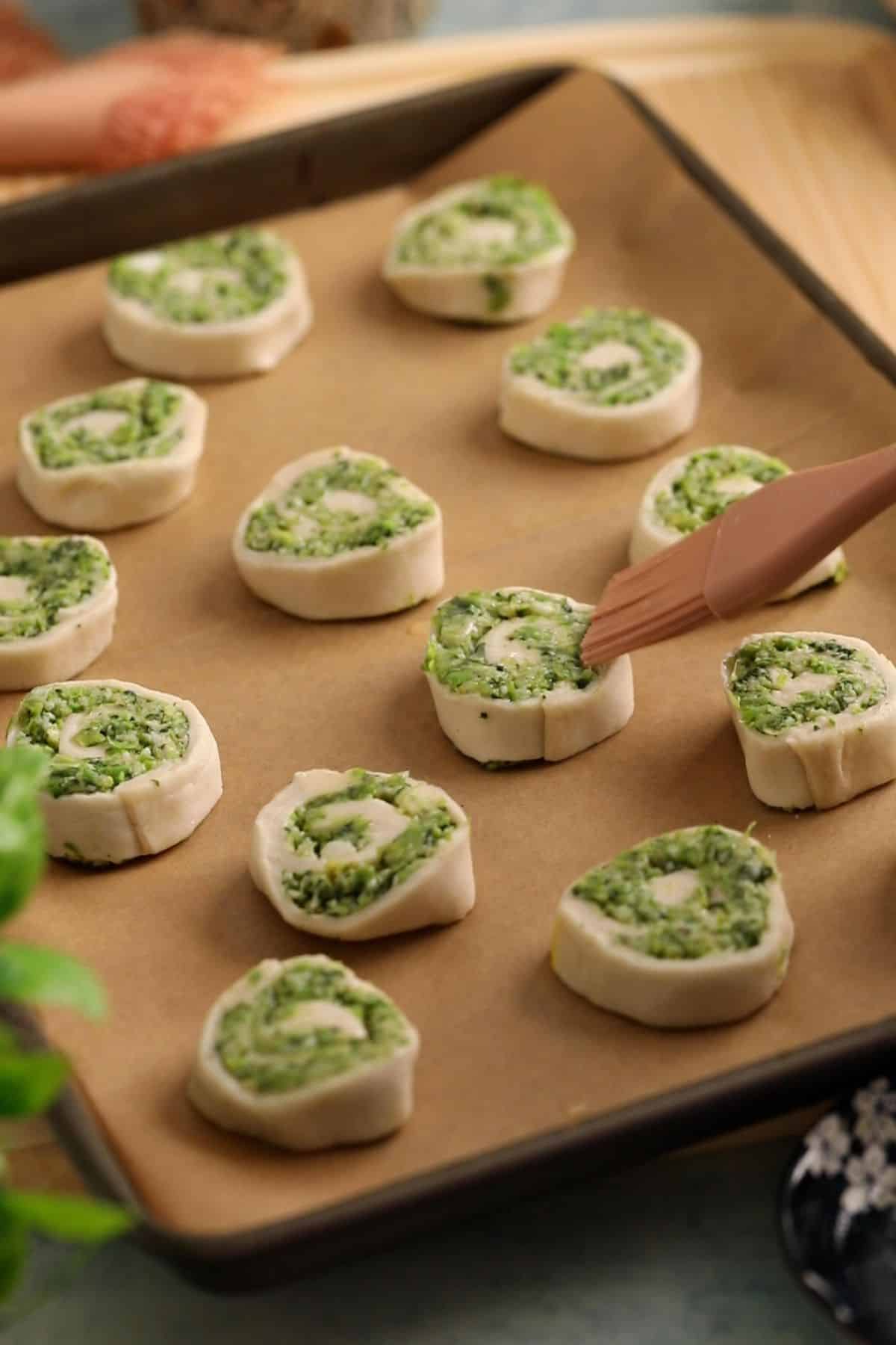 Hara Bhara Kabab Pinwheels - Sinfully Spicy 26 Pinwheels are arraged on a sheet, brished with butter and ready for baking.