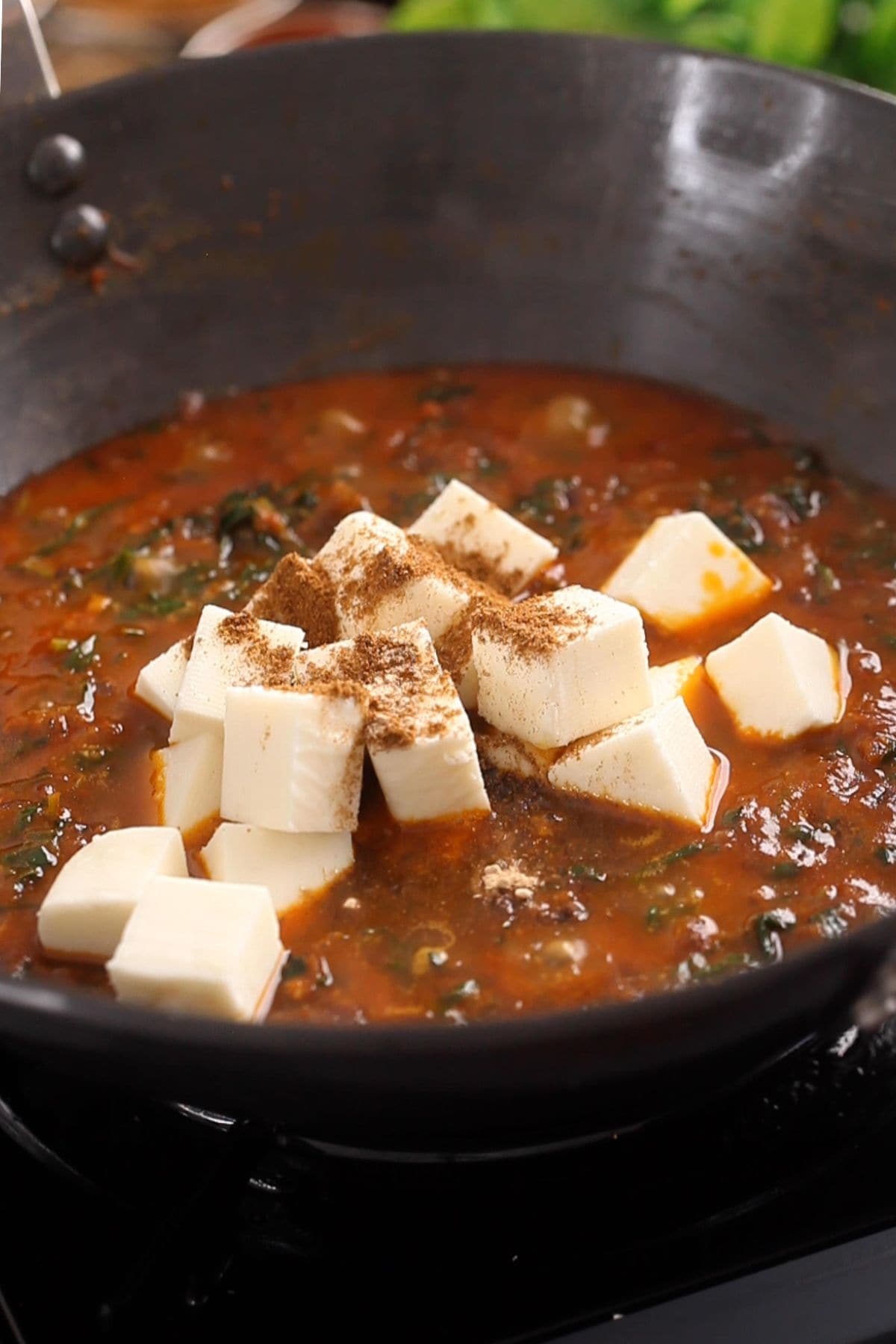 Cubed paneer and finishing spices are added to the methi masala.
