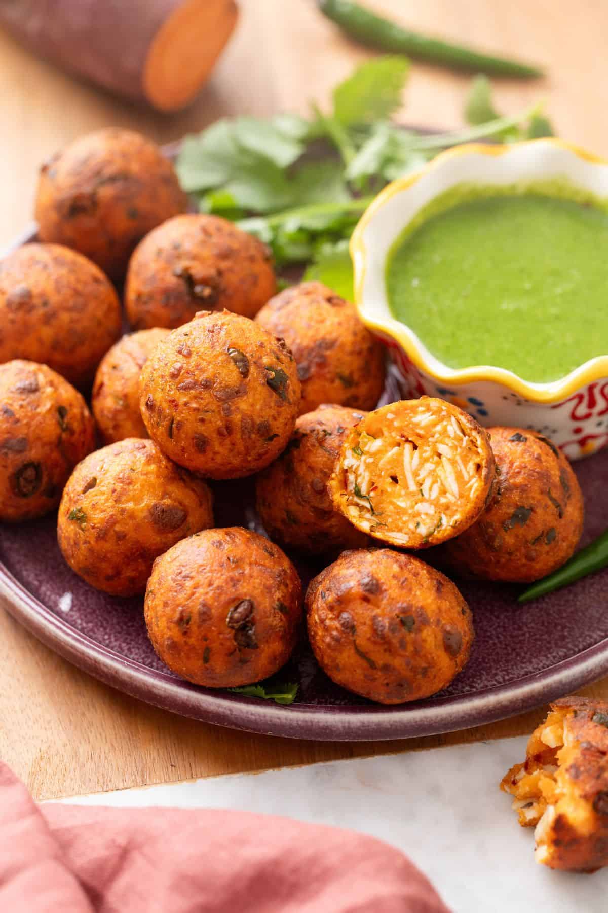 A side image of sweet potato balls with a cut up kofta to show the inside.
