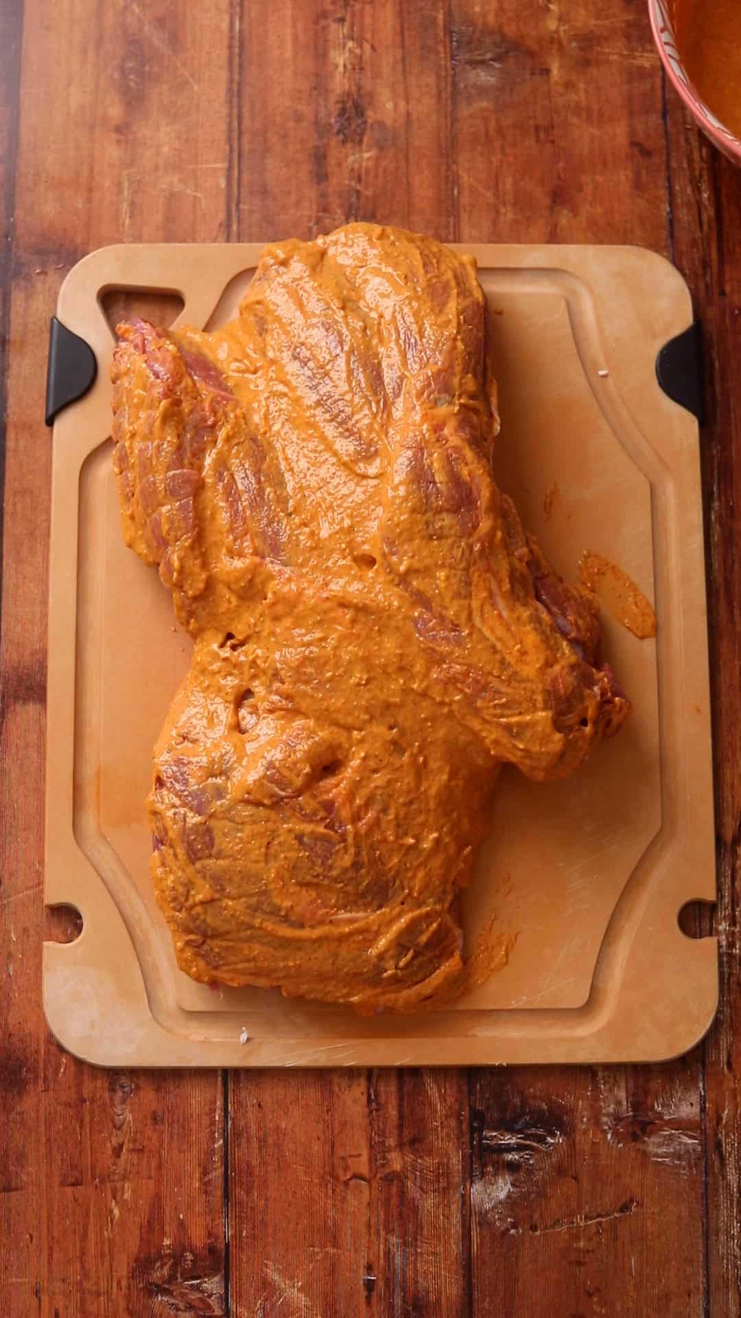 Marinade is brushed on lower part of leg of lamb.