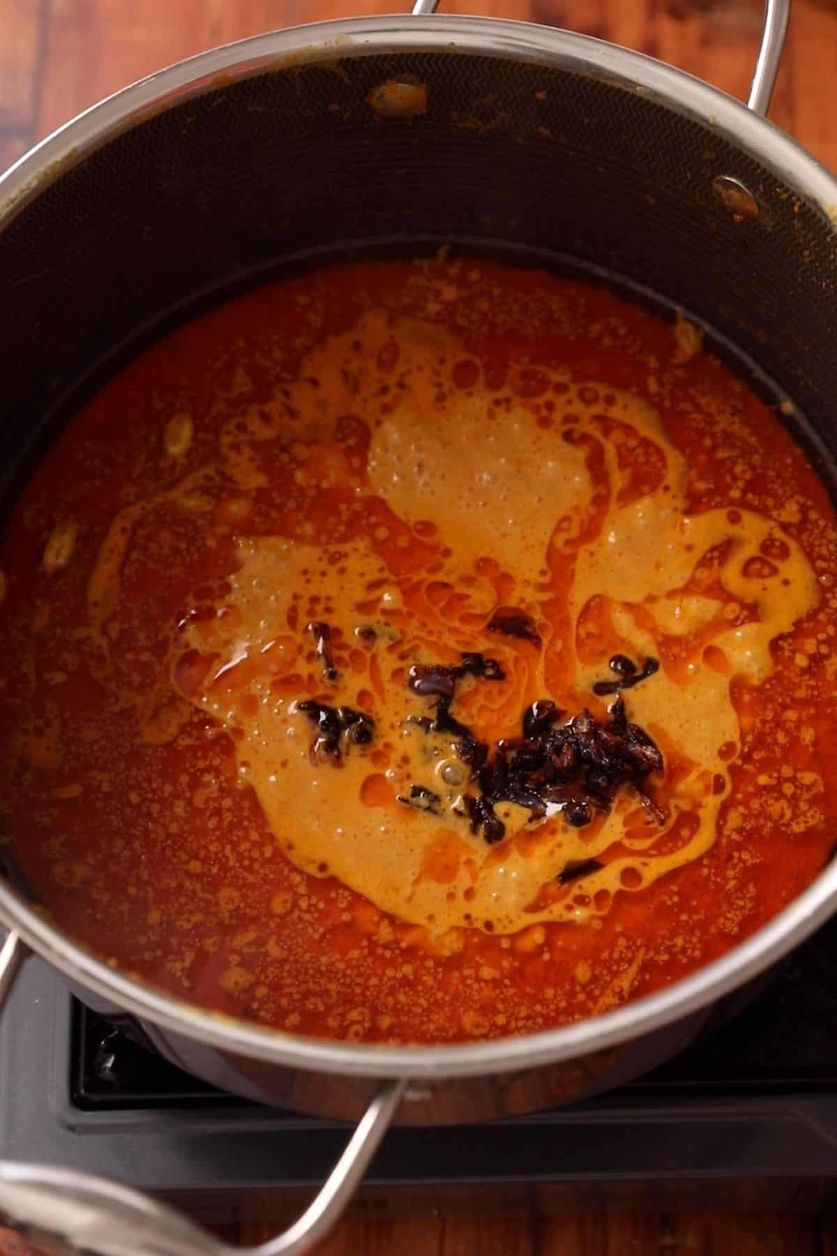 Crushed fried onions are added to the yogurt gravy. 