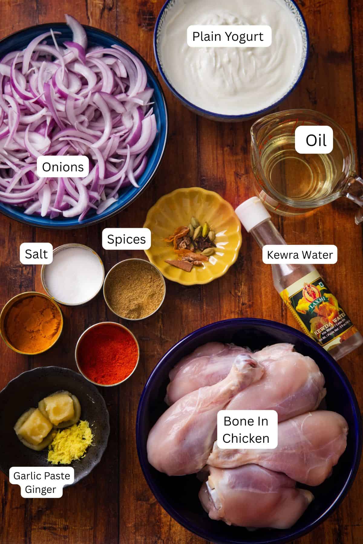 Ingredients needed to make Dill Chicken Korma are placed on a wooden background. 