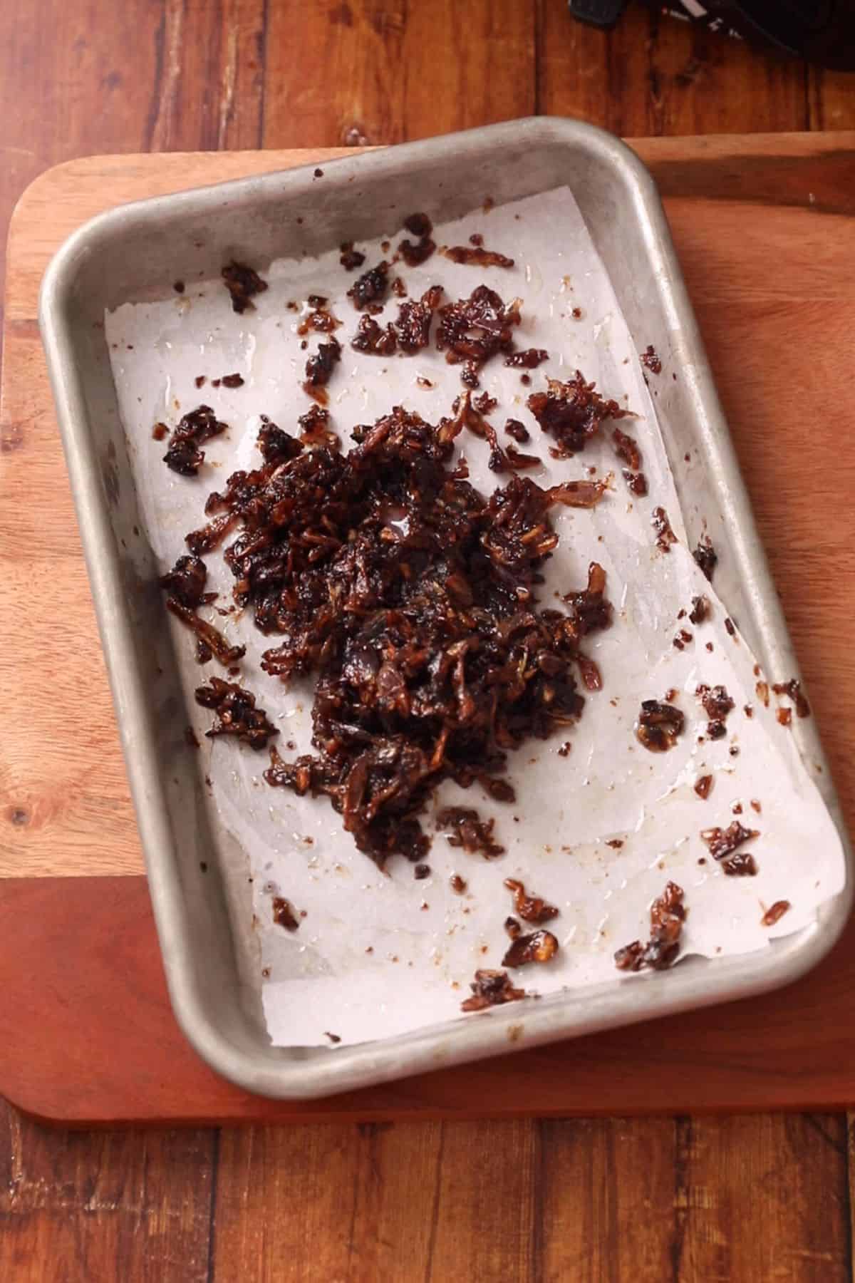 Fried onions are squished by hand to crush them. 