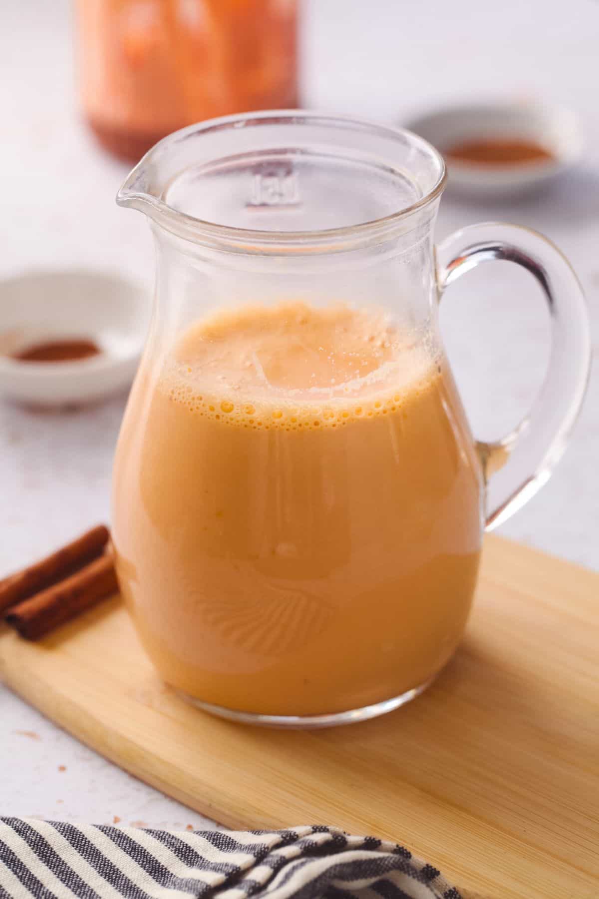 Gajar Doodh in a small jug placed on a bamboo board. 