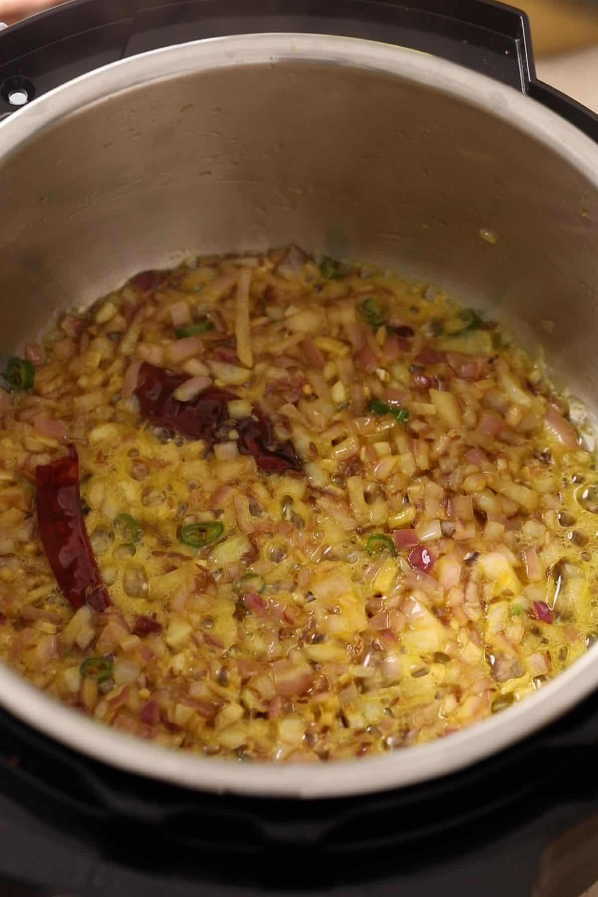 Chopped onions are browning in oil in instant pot.