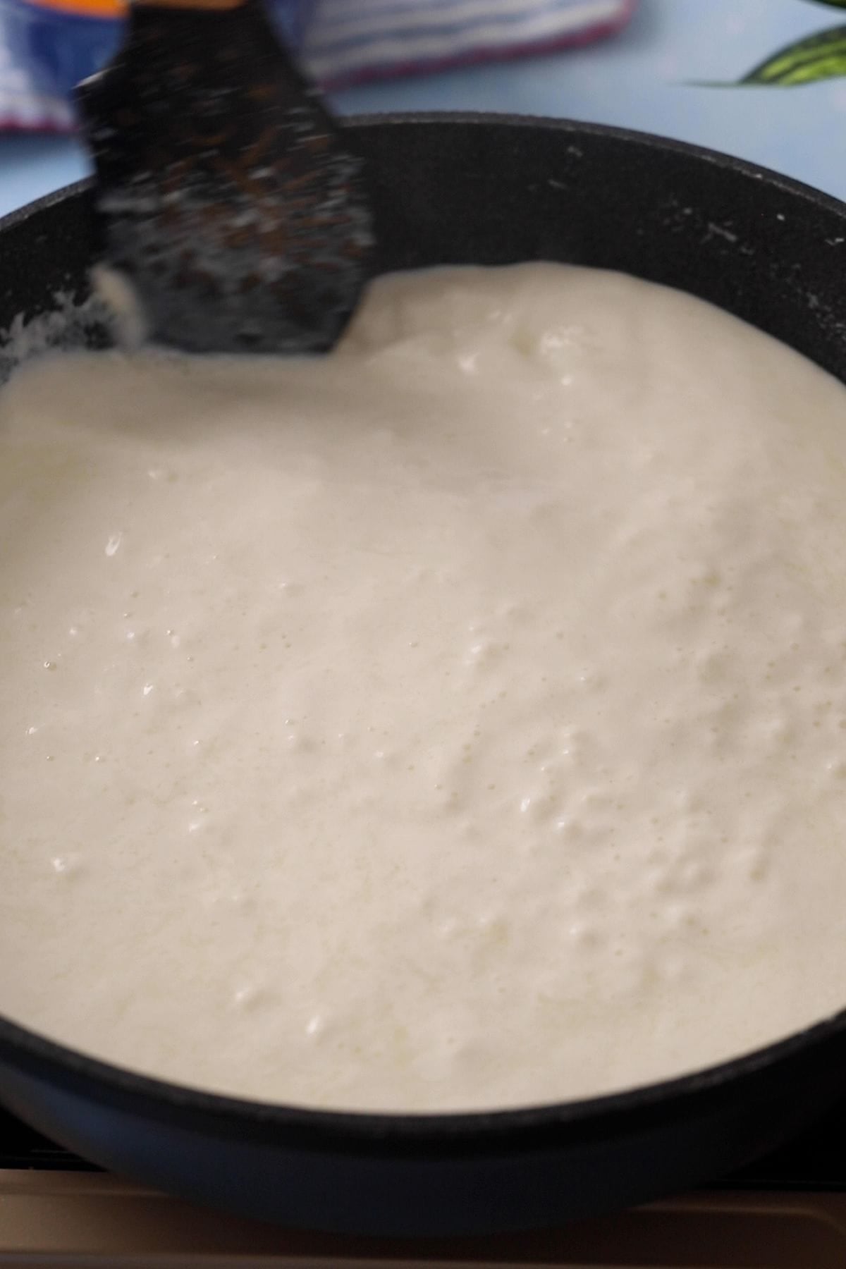 Cream on sides of the pot is scraped and mixed into the milk while its reducing.