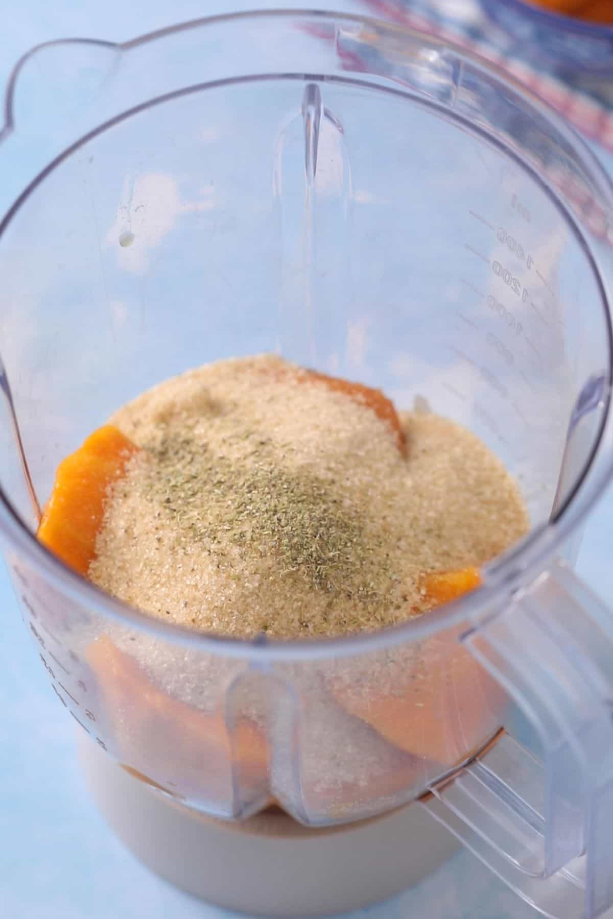 Mango, sugar and cardamom are placed in a blender jar.