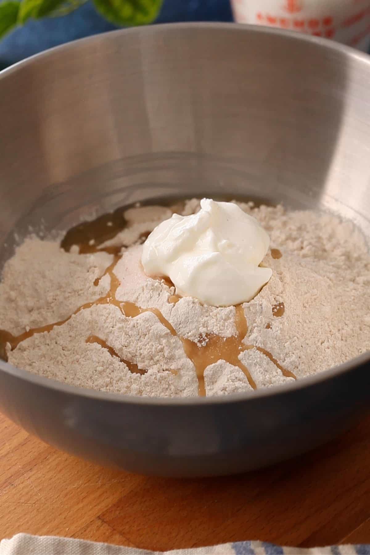 Atta, yogurt, salt and yogurt are added over the yeast mixture.