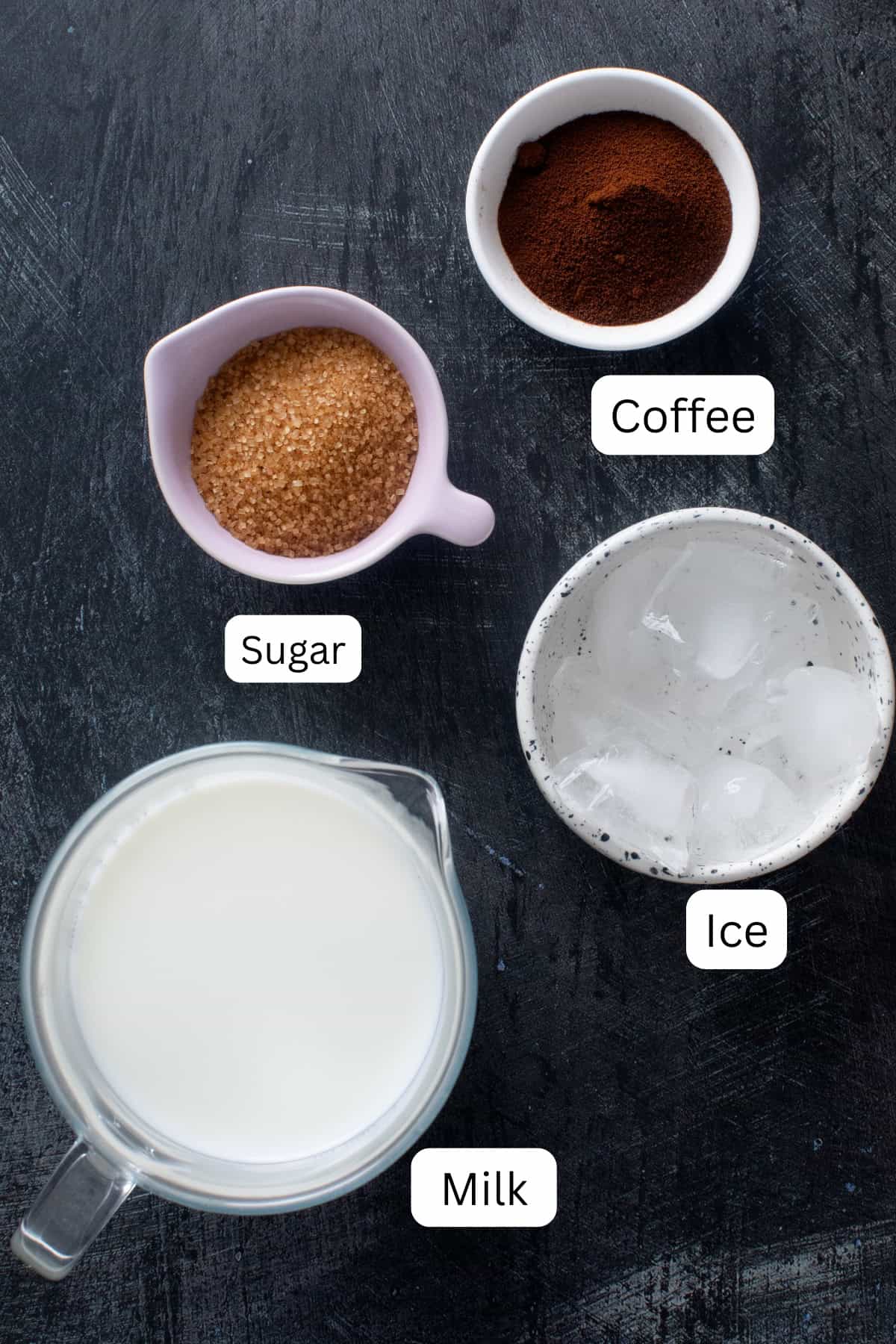 Ingredeints needed to make cold coffee on a black blackground.