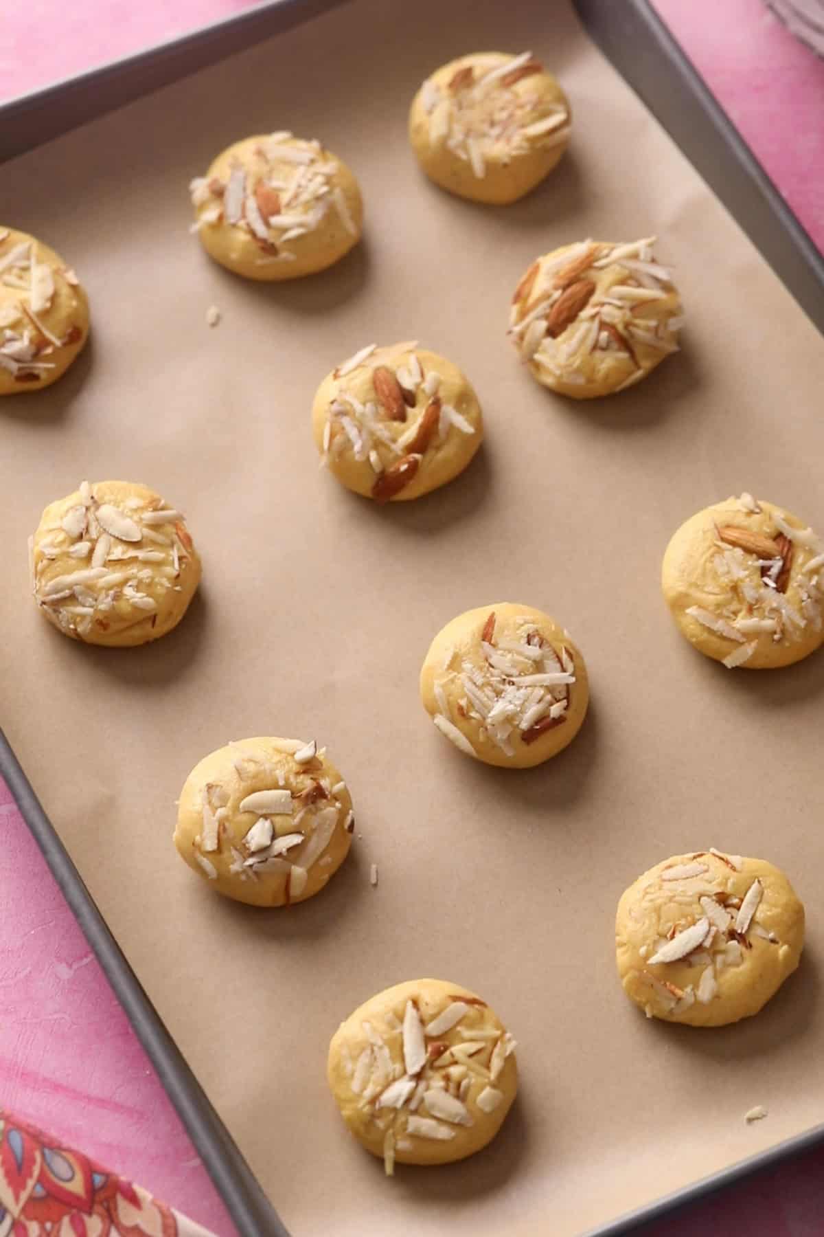 Unbaked nankhatai are placed in a baking sheet.
