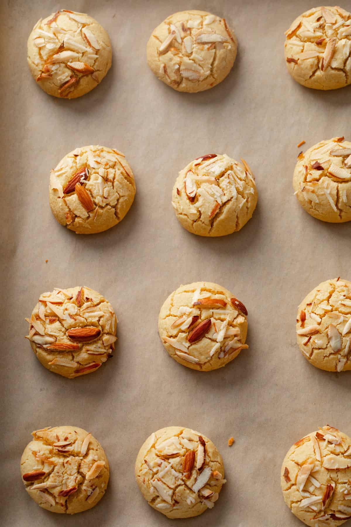 Baked besan nankhatai on a brown parchment lined baking sheet.