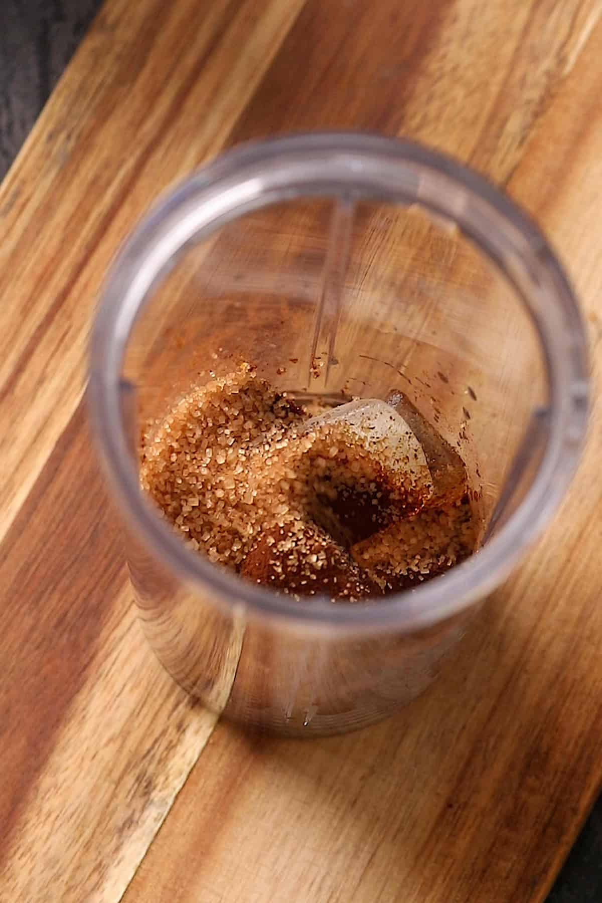 Ice, coffee powder and sugar are placed in a blender jar.