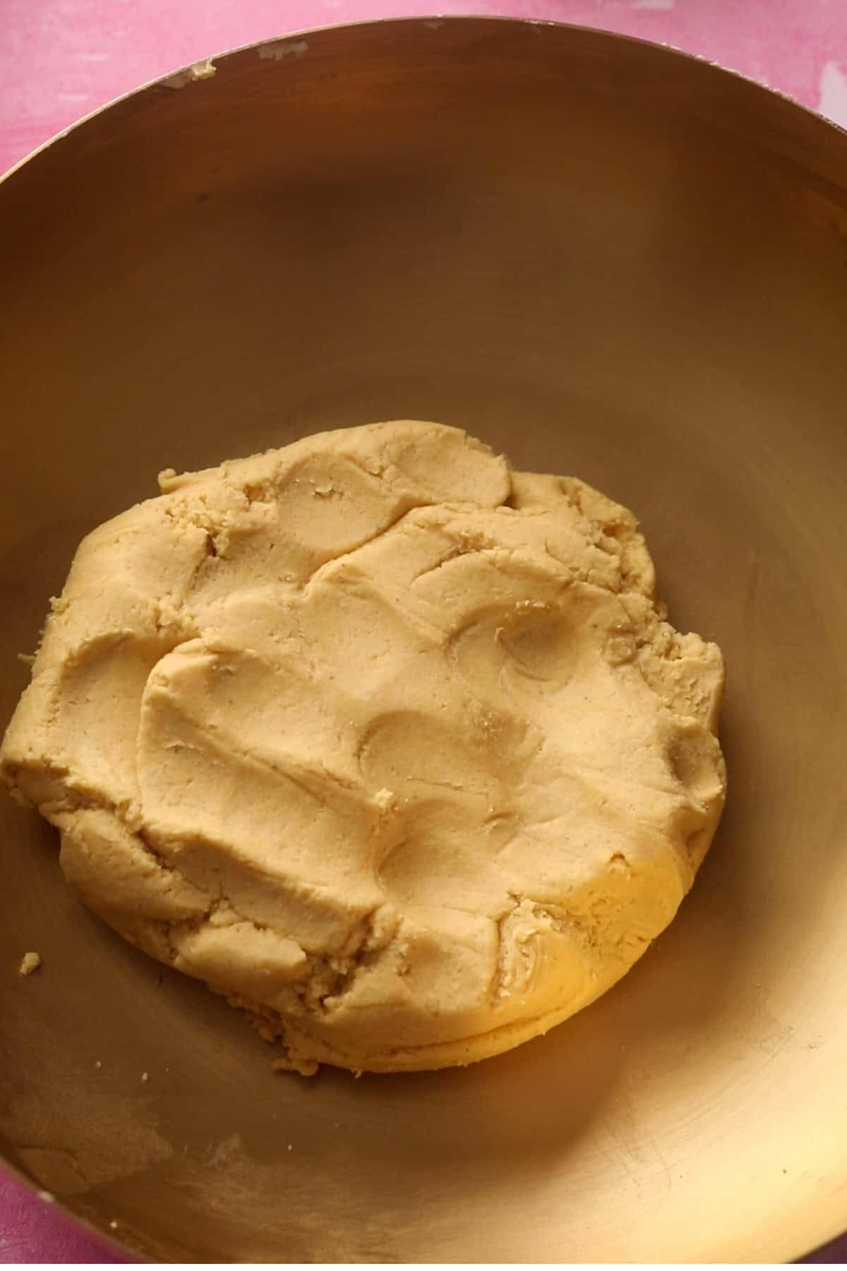 Besan Nankhatai dough in a gold bowl.