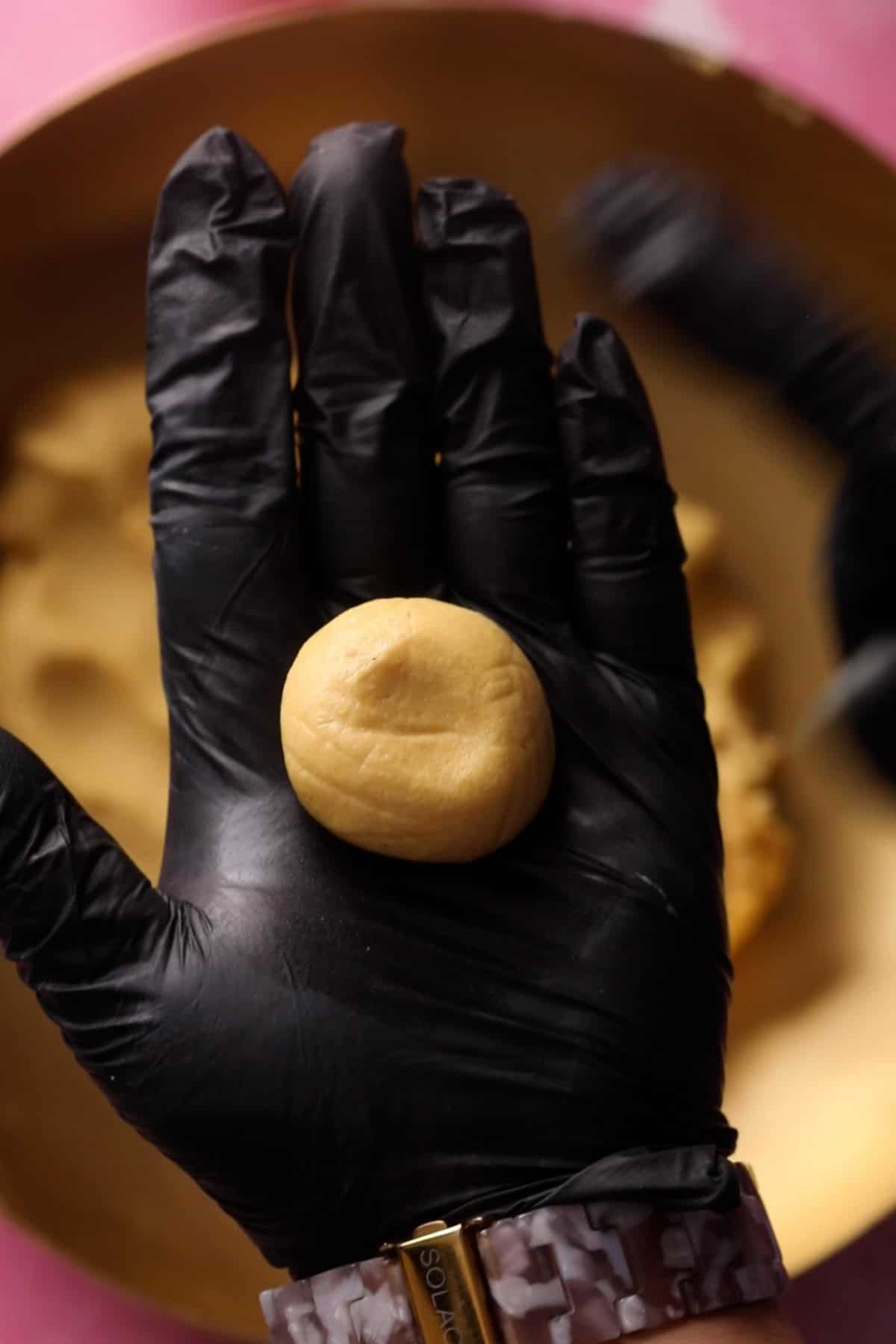 Shaped nankhatai in a gloved hand.