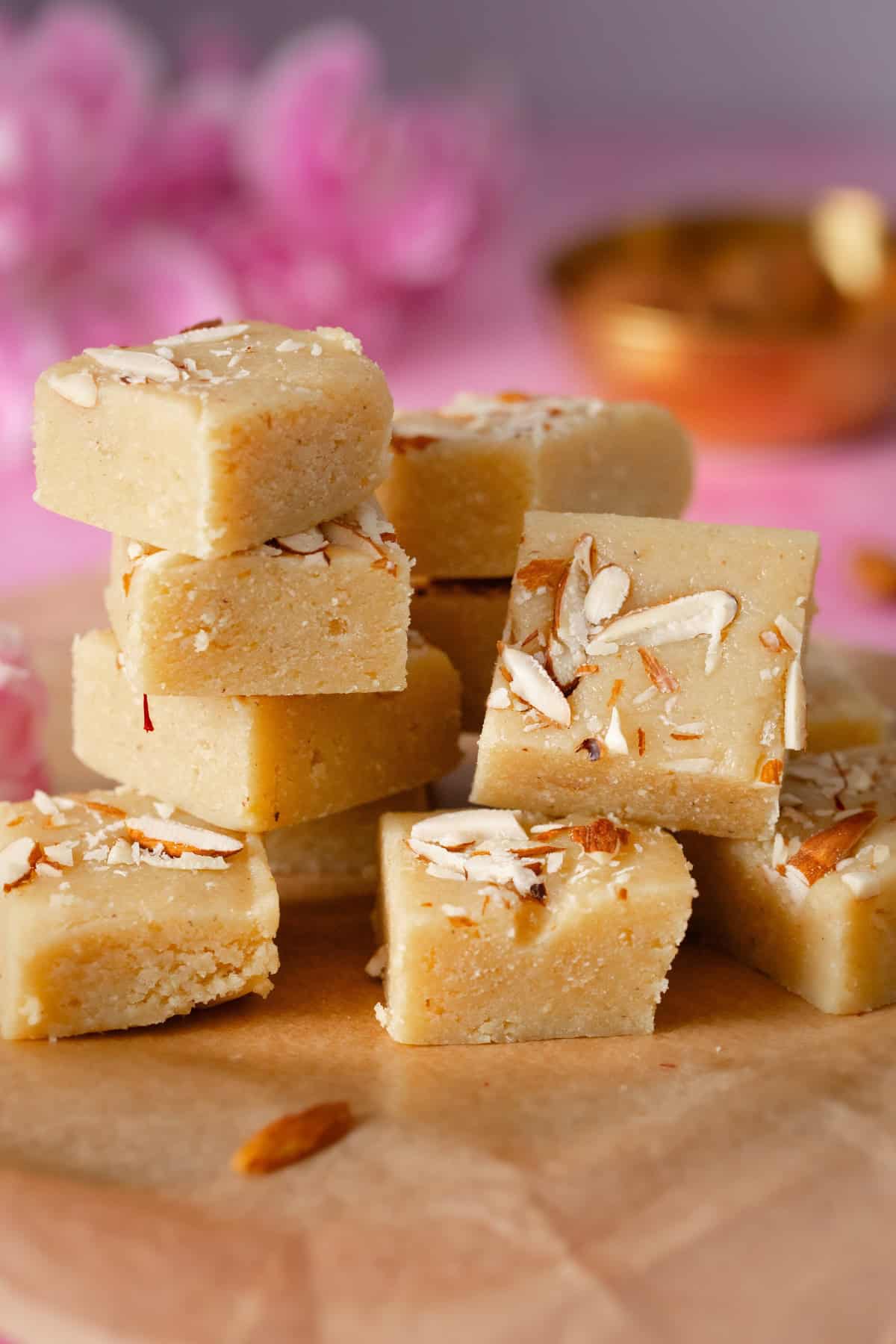 Side view of stacked badam burfi shows thick burfi squares.