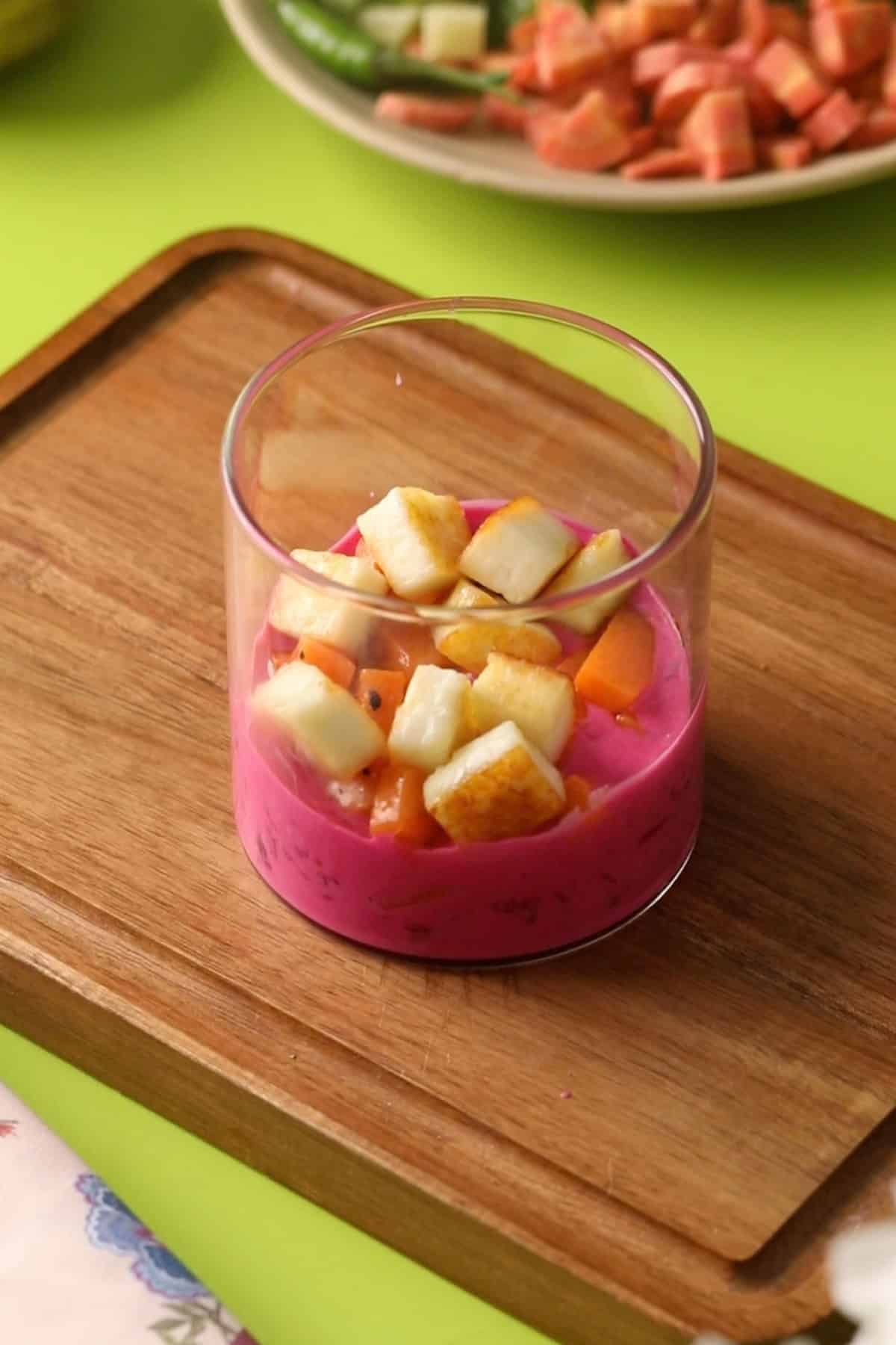 Beet Yogurt, sweet potatoes and paneer in a glass jar.