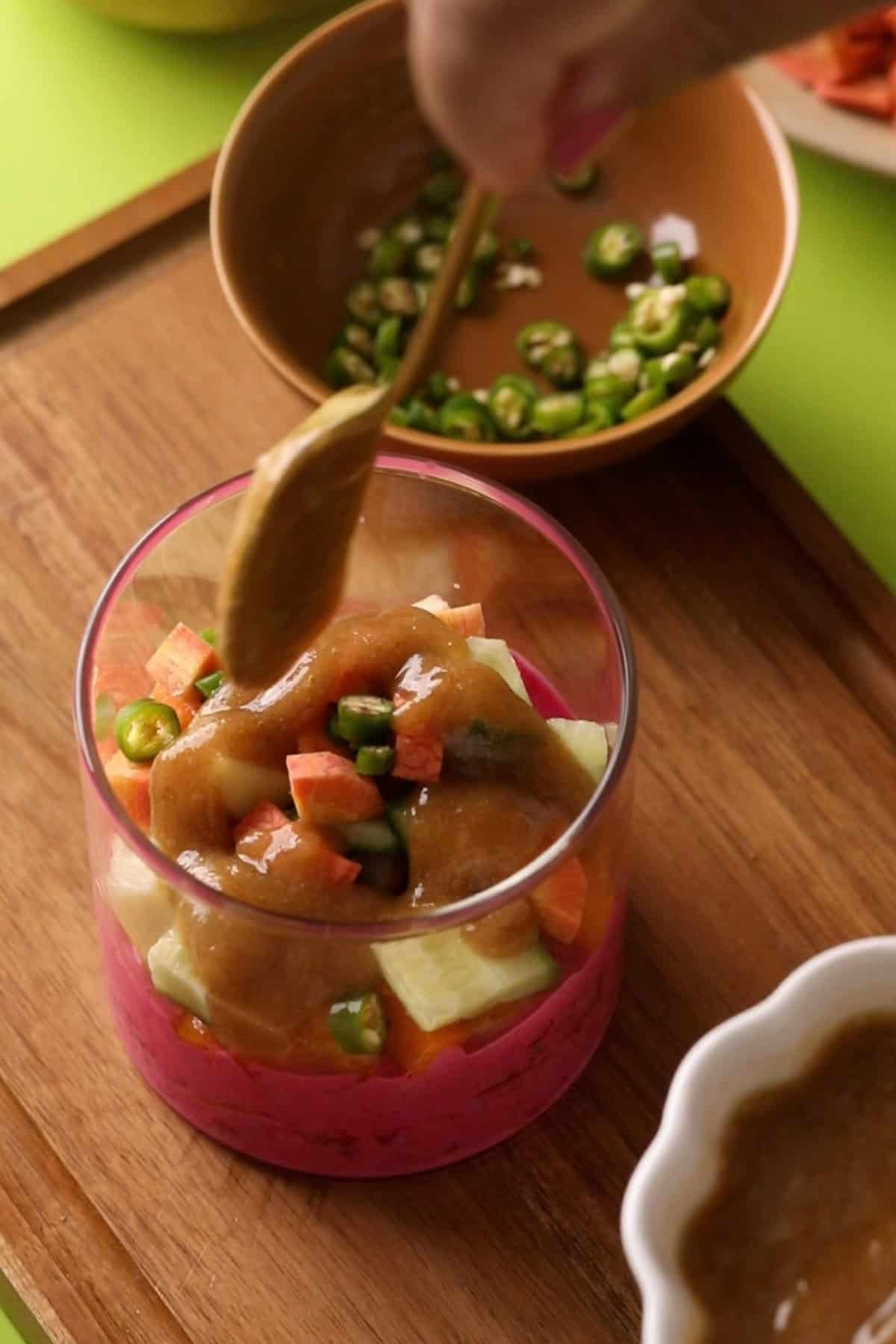 Brown date chutney is added to the chaat cups.